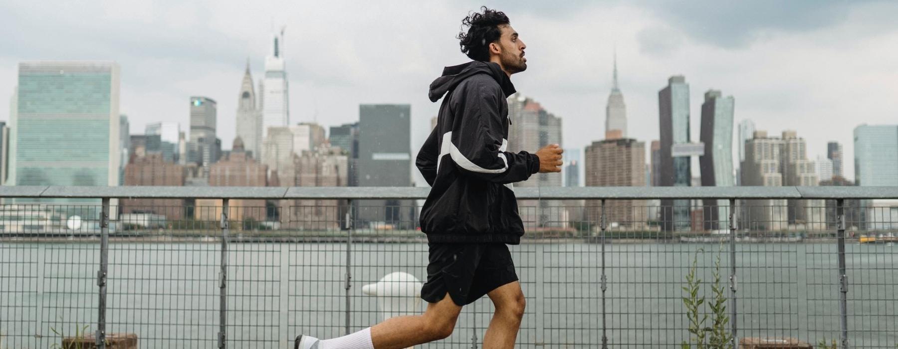 a person running on a stone path with a city skyline in the background