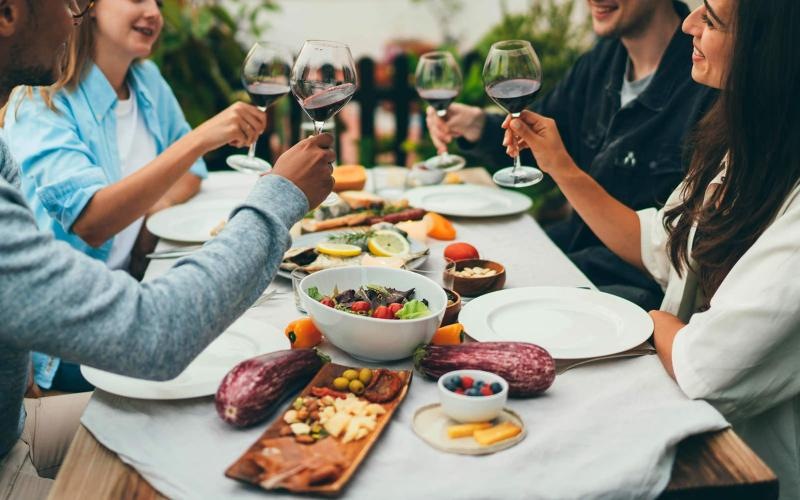 a group of people having a meal around an outdoor table